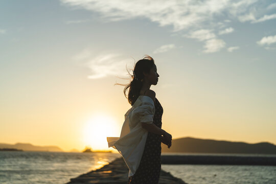 夕暮れの海にいる女性