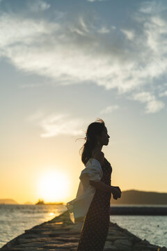 夕暮れの海にいる女性