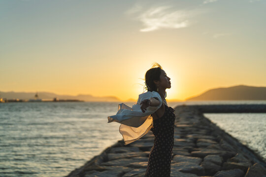 夕暮れの海にいる女性