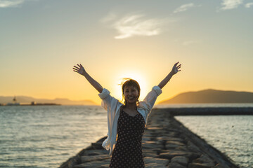Fototapeta premium 夕暮れの海にいる女性