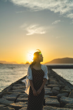 夕暮れの海にいる女性