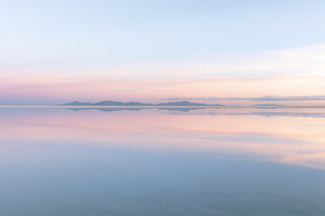 Obraz premium Soft Pastel Reflection of Distant Mountains and Sky on Calm Water