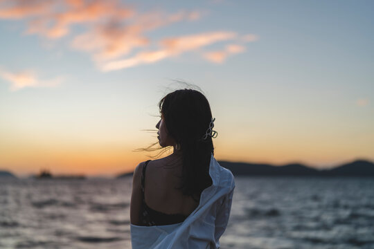 夕暮れの海にいる女性
