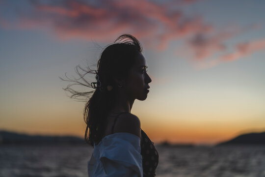 夕暮れの海にいる女性