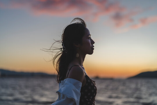 夕暮れの海にいる女性