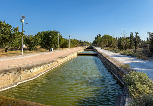 Rippled canal beside walking paths and solar lights in Antonis Tritsis Park, West Attica, Greece