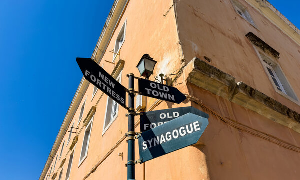 Black directional signpost to old town fortress and synagogue, Corfu Old Town, Greece