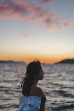 夕暮れの海にいる女性