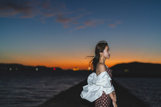 夕暮れの海にいる女性