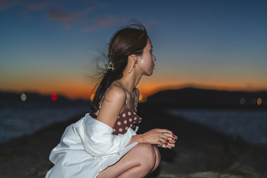 夕暮れの海にいる女性
