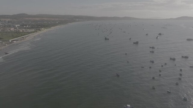 Aerial drone view of Mui Ne fishing village and Ganh Da Mui Ne coastline in Lam Dong, Vietnam, with fishing boats at sea, sandy beaches and a scenic coastal landscape.