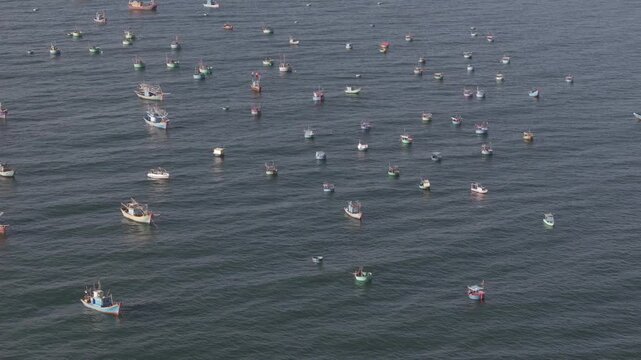 Aerial drone view of Mui Ne fishing village and Ganh Da Mui Ne coastline in Lam Dong, Vietnam, with fishing boats at sea, sandy beaches and a scenic coastal landscape.
