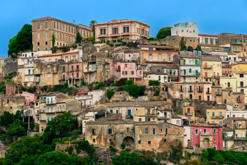 Naklejka premium Colorful ancient stone buildings cascade down a hillside under a clear blue sky