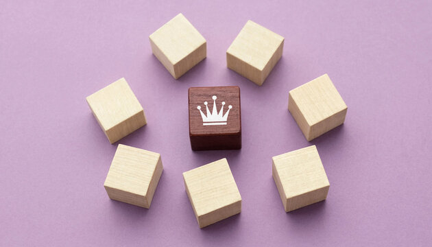 Leadership concept with wooden cube featuring crown surrounded by plain cubes on purple background