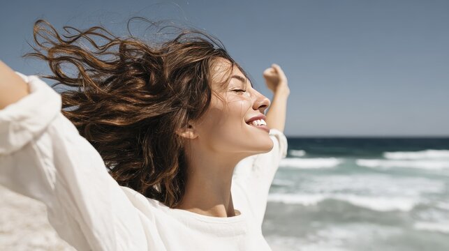 Joyful woman embracing freedom at the beach with arms outstretched on a sunny day