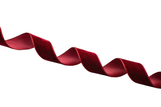 A single wavy strip of deep red velvet ribbon curled into soft loops on a plain white surface isolated on a transparent background