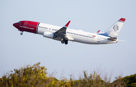 BARCELONA, SPAIN - AUGUST 18, 2023: Norwegian Air Shuttle passenger aircraft in traditional white and red livery with portrait of Swedish opera singer Jenny Lind on tail fin taking off from Barcelona