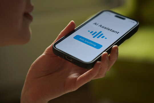 Woman speaks into smartphone using artificial intelligence assistant