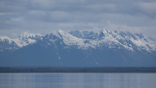 Breathtaking Alaska mountain glacier range view seen from outdoor deck of cruise ship liner sailing the Inside Passage transit with spectacular landscape wilderness scenery