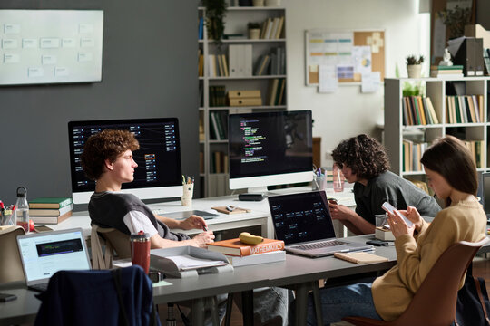 Young man and young woman learn programming in university class