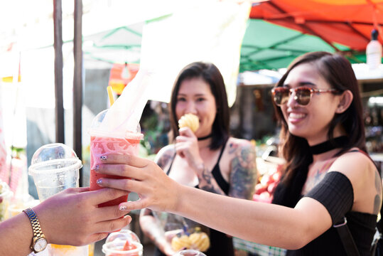 Woman buying a smoothie from a street vendor in Thailand