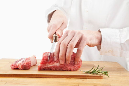 Man cutting meat on chopping board