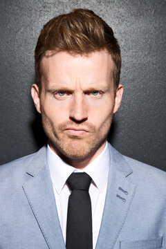 Portrait of businessman making funny faces, close up