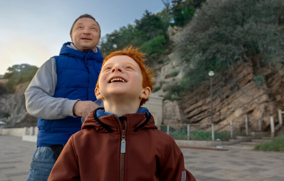 Father and son admire nature on the beach promenade