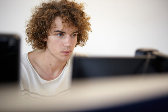 Young man in office looking at computer screen
