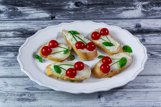 Creative camembert crostini with cherry tomatoes on a white plate