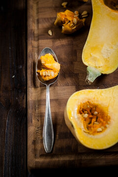 Deseeding a butternut squash, Cucurbita moschata, with a spoon