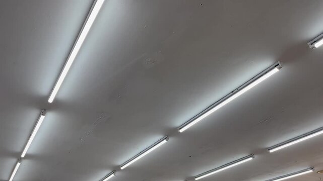 Low angle view of triple parallel LED tube lights on ceiling