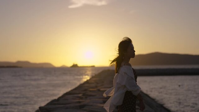 夕暮れの海にいる女性