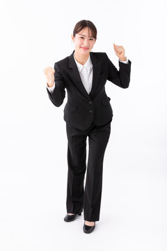 ガッツポーズをする若いスーツの女性