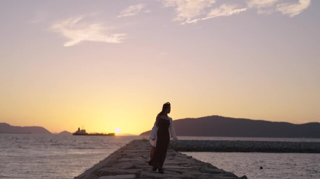 夕暮れの海にいる女性