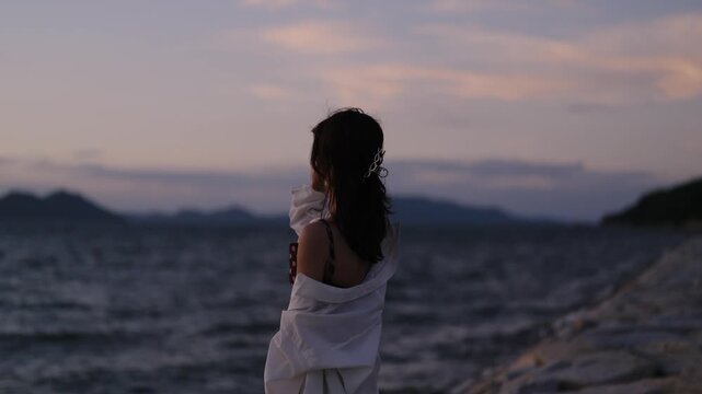 夕暮れの海にいる女性