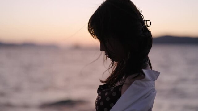 夕暮れの海にいる女性
