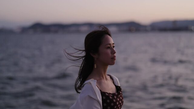 夕暮れの海にいる女性