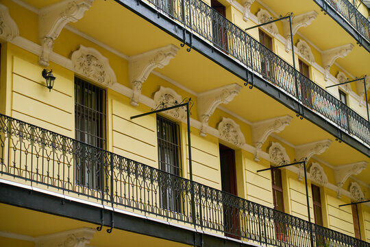 Ornate iron balconies on yellow apartment building facade