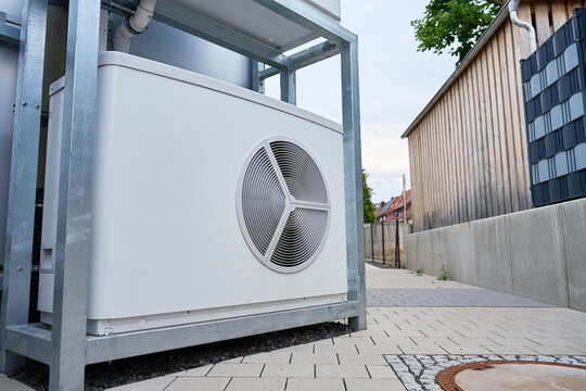 Outdoor heat pump unit installed beside residential building in city