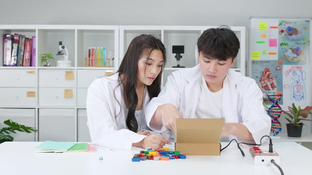 Teenage Students Conducting Science Experiment with Plastic Bricks in Classroom