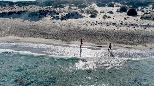 Simos Beach in Elafonisos Greece showcases stunning turquoise waters and golden sands. Visitors wander along the shoreline, enjoying the natural beauty and tranquility of this hidden gem in summer.