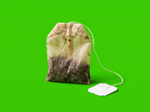 Used Wet Tea Bag with String Isolated on Green Background