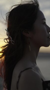 夕暮れの海にいる女性