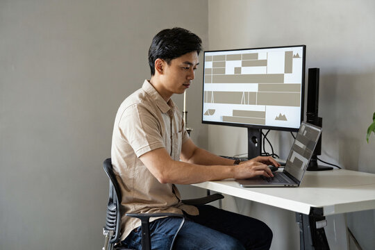 Professional knowledge worker at a clean desk with dual screens