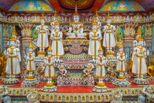 White Buddha statues with gold adornments seated and standing inside the shrine hall at Wat Sri Uthumphon in Mueang Nakhon Sawan District, Nakhon Sawan, Thailand, rich in details.