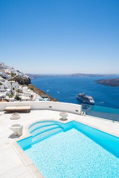 White architecture in Santorini island, Greece. Blue sea and the blue sky at sunny day. Luxury swimming pool with blue water.