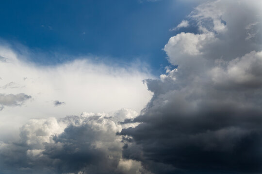 Dramatic contrast between dark thunderstorm clouds and clear blue sky.