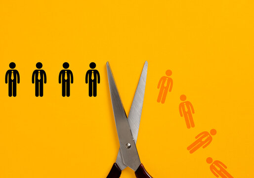 Scissors cutting employees illustrating job loss and downsizing