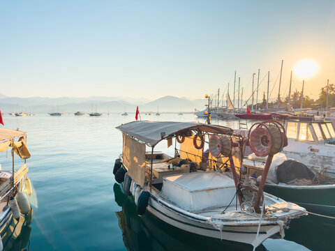 Fishing boats moored on the pier in Fethiye, Turkey.. Blue sea and the blue sky at sunrise.